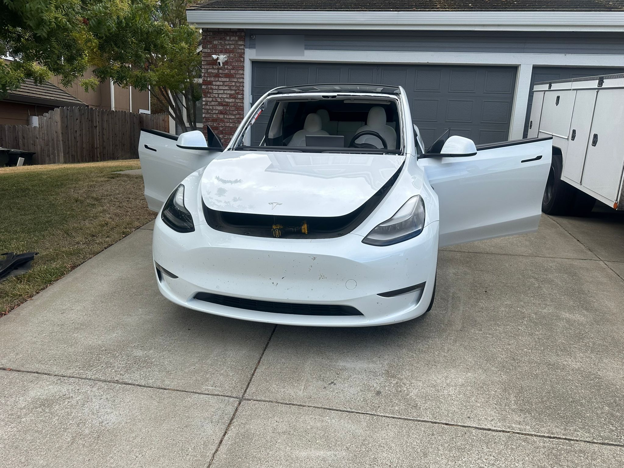 White Tesla Model Y in driveway during mobile windshield replacement service by Gateway Auto Glass